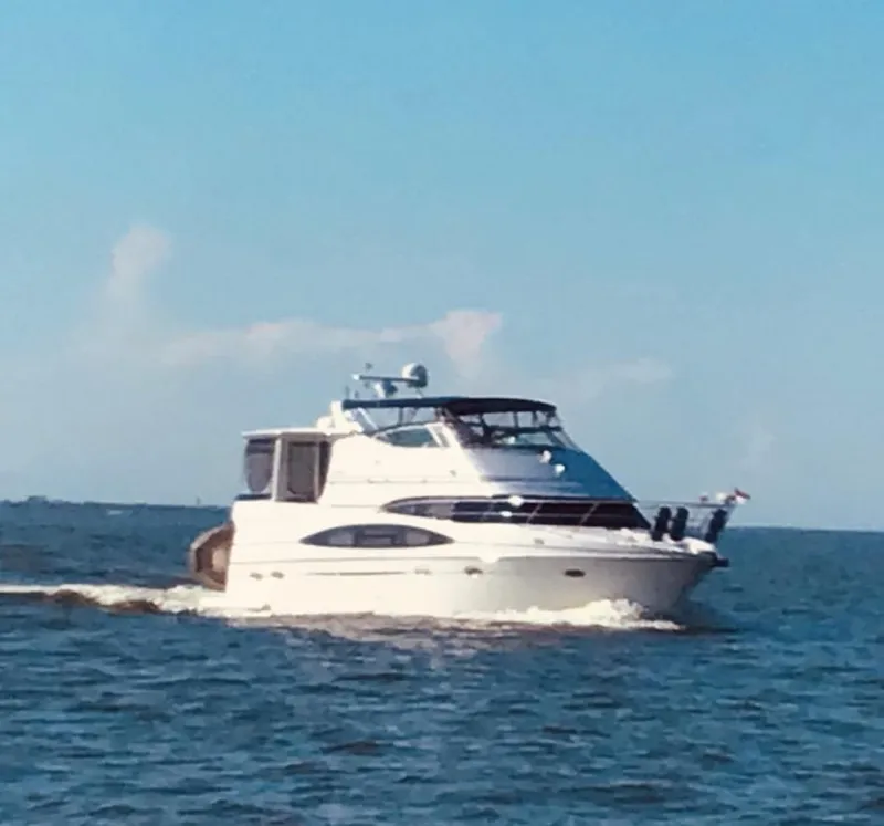 Slide: The Image of 2001 Carver 466 Motor Yacht cruising on open water under a clear blue sky. - 2