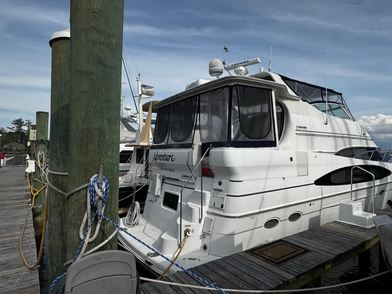 Slide: The Image of 2001 Carver 466 Motor Yacht docked at a marina, showcasing its sleek design. - 4