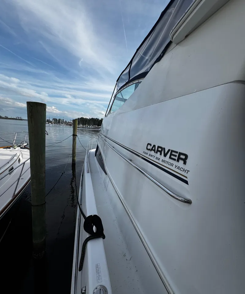 Slide: The Image of 2001 Carver 466 Motor Yacht docked by a serene waterfront. - 11