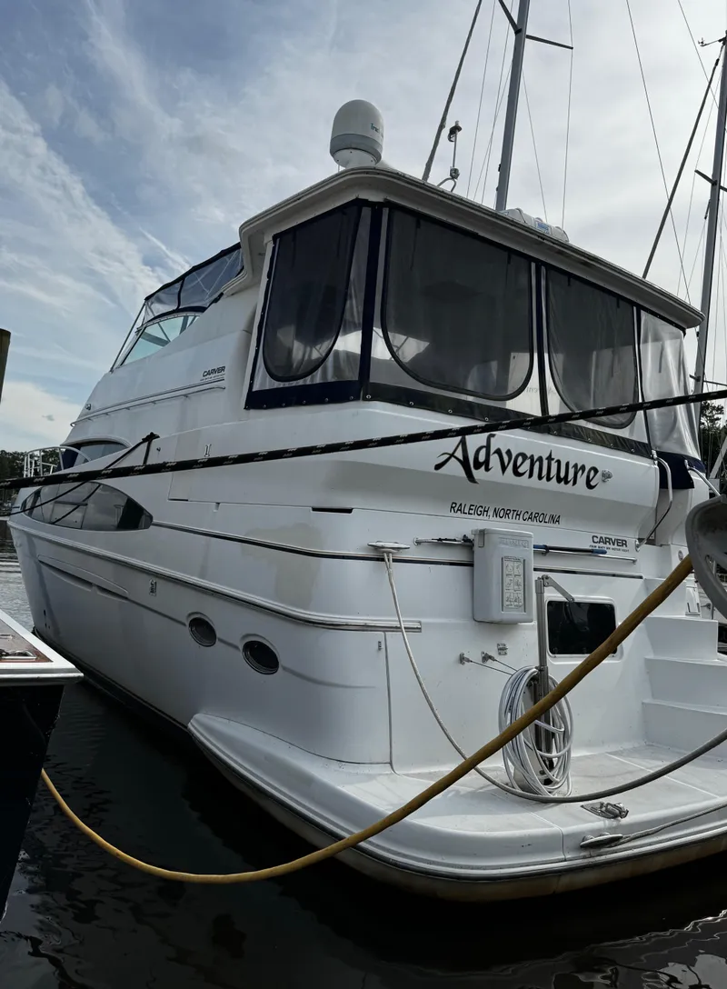 Slide: The Image of 2001 Carver 466 Motor Yacht docked, featuring sleek design and spacious deck. - 3