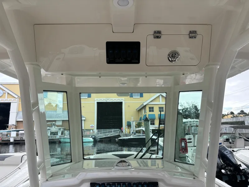 Slide: The Image of 2023 Sailfish 272 CC boat interior with windshield and control panel at marina. - 11
