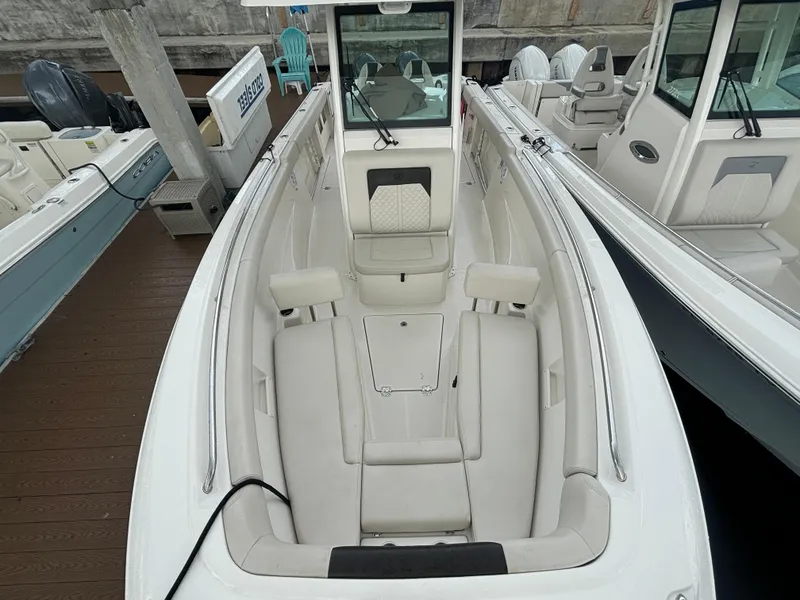 Slide: The Image of 2023 Sailfish 272 CC boat interior with white seating and console, docked at marina. - 14