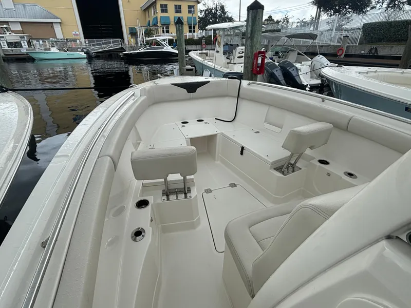 Slide: The Image of 2023 Sailfish 272 CC boat interior with seating and cup holders at a marina. - 16