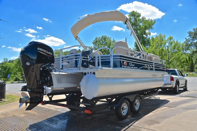 Slide: The Image of 2023 Sun Tracker Fishin Barge 20 DLX on trailer, parked near a lake. - 14
