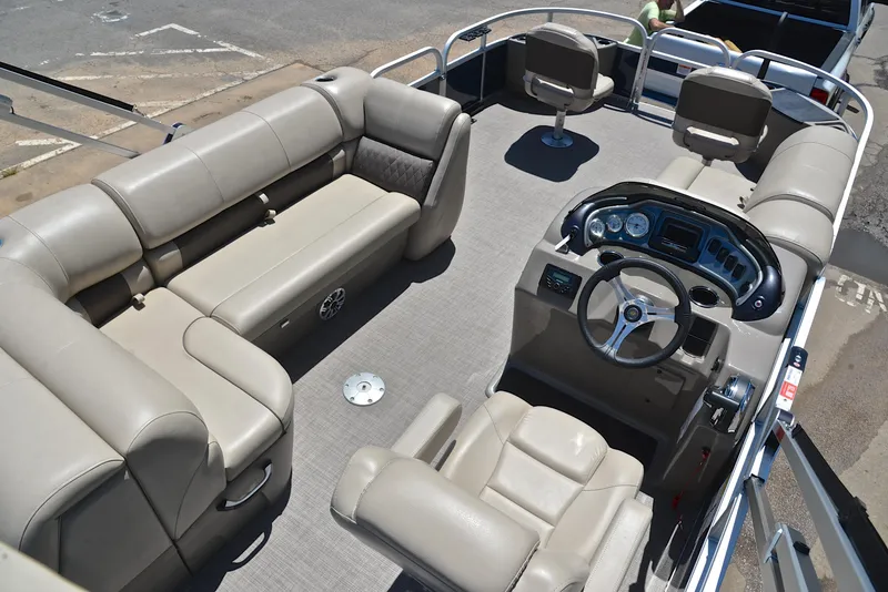 Slide: The Image of 2023 Sun Tracker Fishin Barge 20 DLX interior with beige seating and steering console. - 19