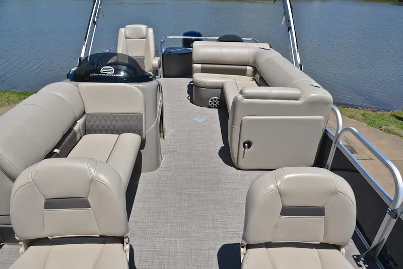 Slide: The Image of 2023 Sun Tracker Fishin Barge 20 DLX interior with beige seating and lake view. - 20
