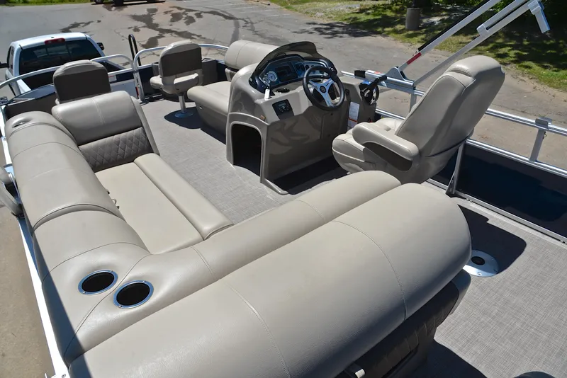 Slide: The Image of 2023 Sun Tracker Fishin Barge 20 DLX interior with beige seating and steering console. - 24