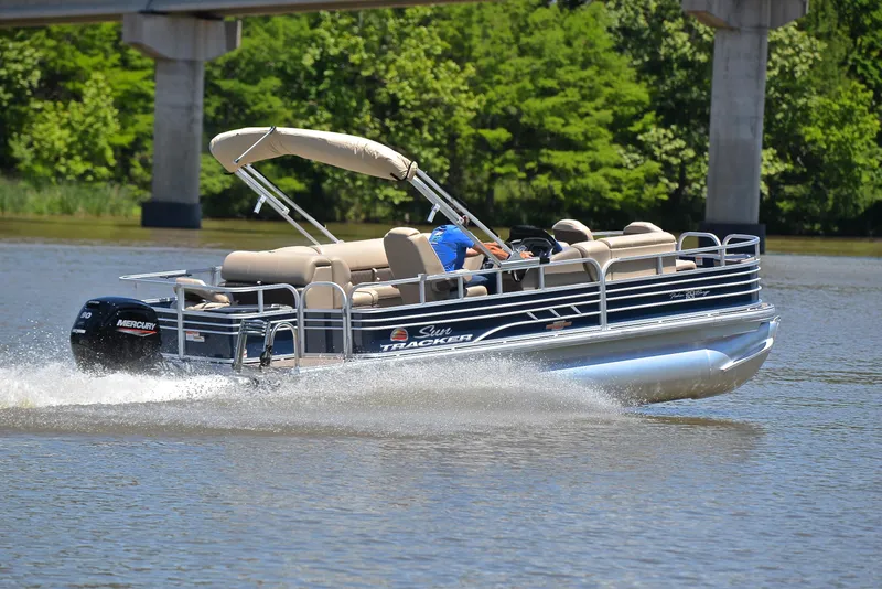 Slide: The Image of 2023 Sun Tracker Fishin Barge 20 DLX pontoon boat cruising on a lake. - 5
