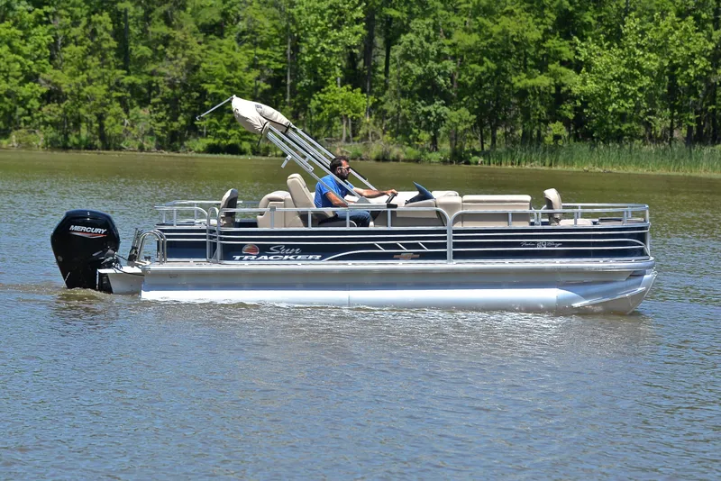Slide: The Image of 2023 Sun Tracker Fishin Barge 20 DLX pontoon boat cruising on a lake. - 6