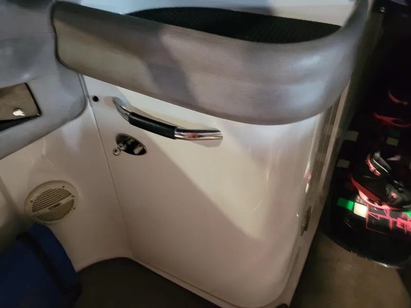 Slide: The Image of Interior view of a 2004 Cobalt 282 boat, featuring a sleek white panel and chrome handle. - 13