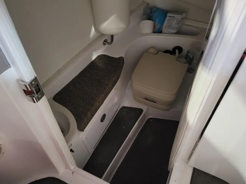 Slide: The Image of 2004 Cobalt 282 boat interior with compact bathroom and portable toilet. - 14