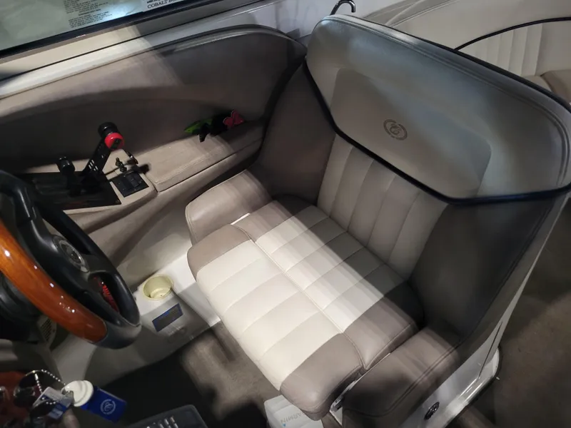 Slide: The Image of 2004 Cobalt 282 boat interior with steering wheel and cushioned seat. - 5
