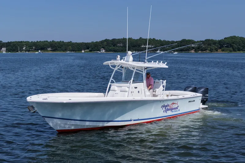 Slide: The Image of 2013 Regulator 34 Center Console boat cruising on a calm lake with scenic background. - 10