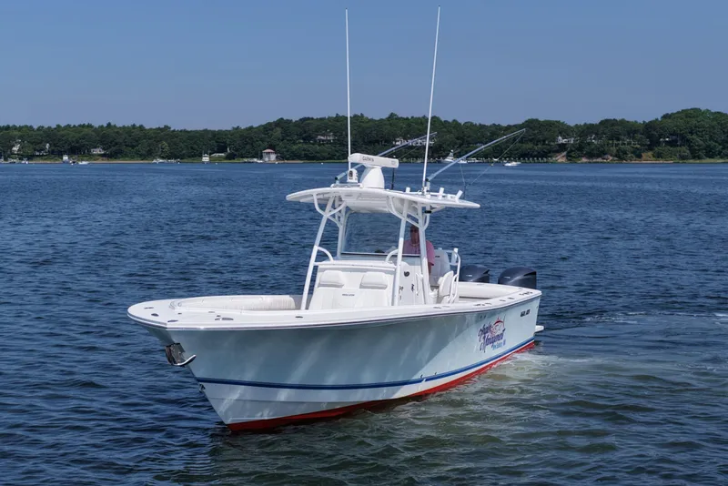 Slide: The Image of 2013 Regulator 34 Center Console boat on calm water, clear sky background. - 11