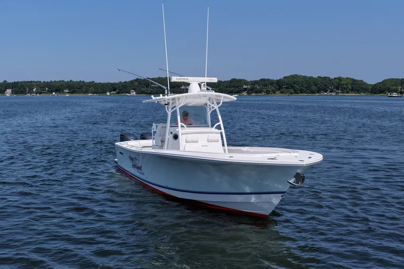 Slide: The Image of 2013 Regulator 34 Center Console boat on calm water, clear sky background. - 13