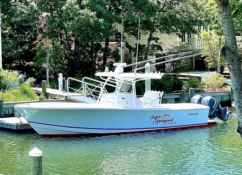 Slide: The Image of 2013 Regulator 34 Center Console boat docked in a scenic marina. - 15