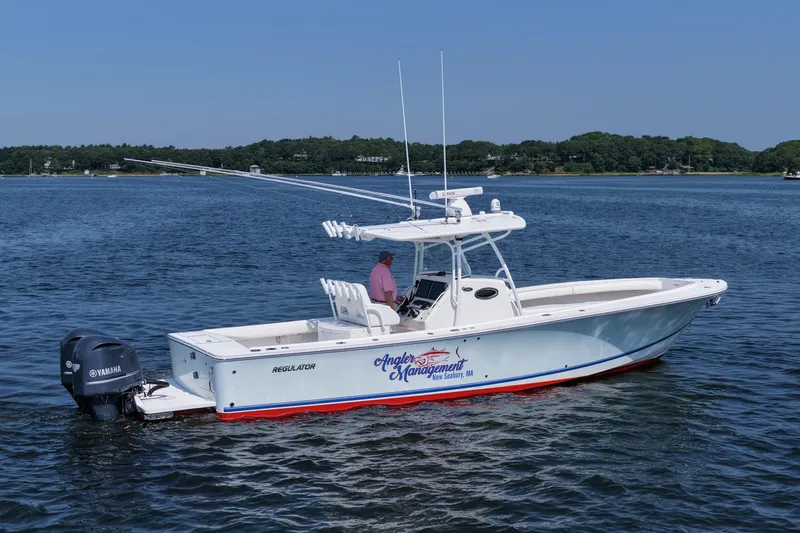 Slide: The Image of 2013 Regulator 34 Center Console boat on water, featuring Yamaha engines. - 2