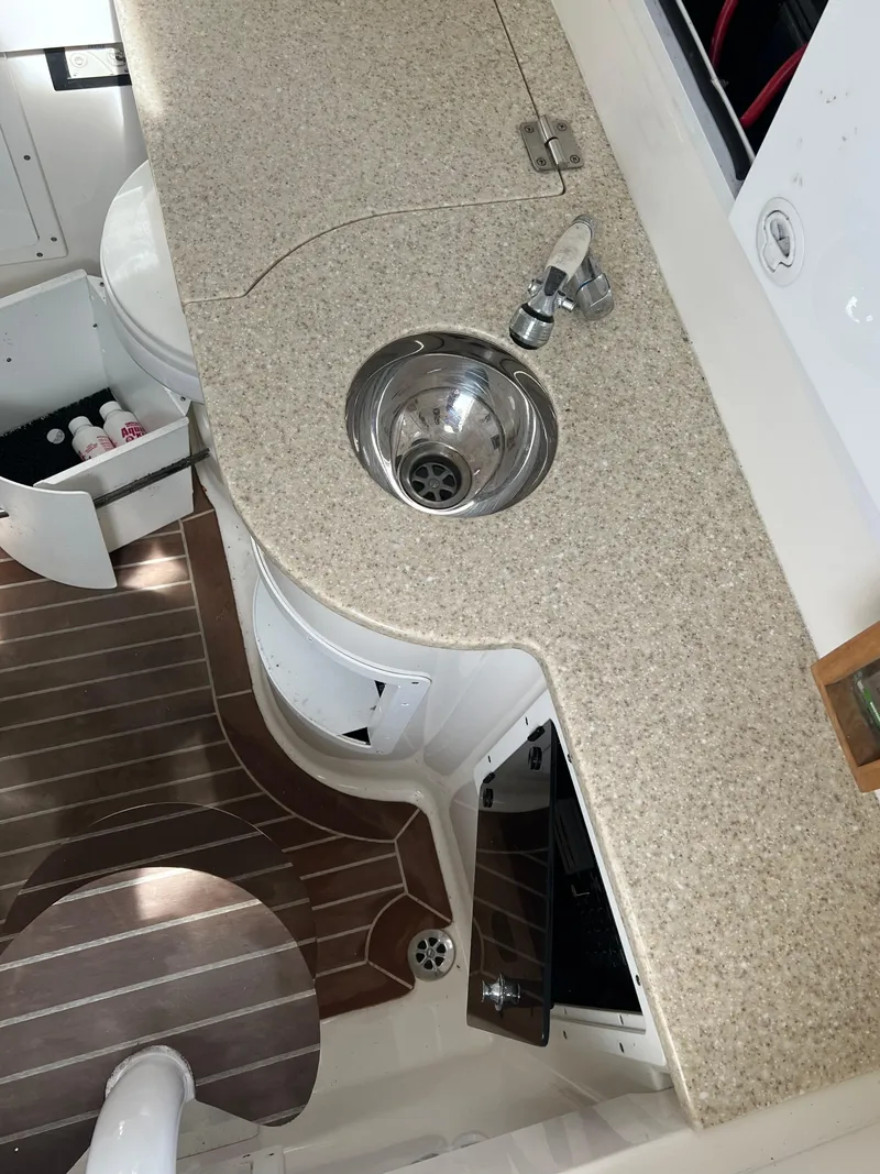 Slide: The Image of 2013 Regulator 34 Center Console boat interior with sink and wooden flooring. - 22