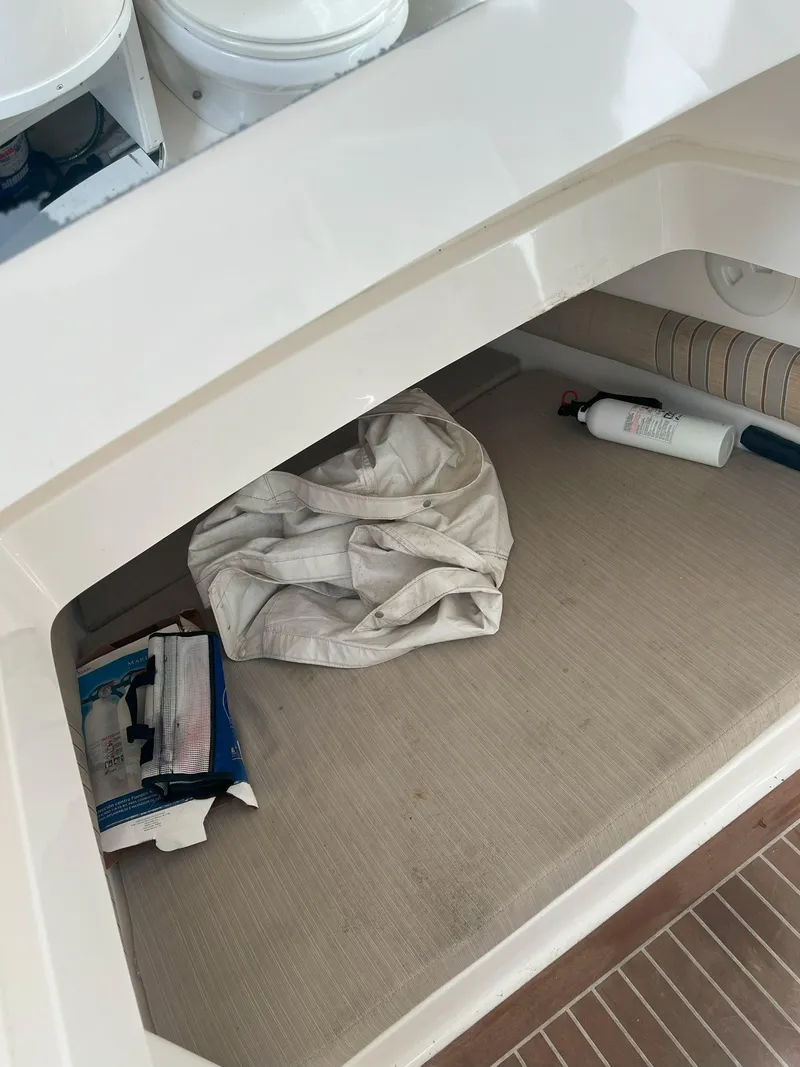 Slide: The Image of 2013 Regulator 34 Center Console storage area with items and beige cushion. - 24