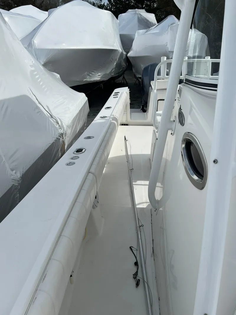 Slide: The Image of 2013 Regulator 34 Center Console boat, docked with covered vessels nearby. - 28