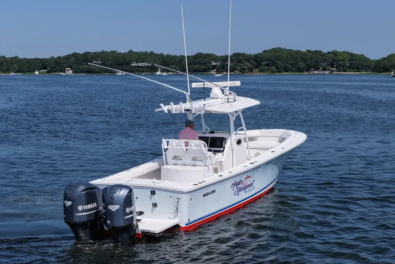 Slide: The Image of 2013 Regulator 34 Center Console boat with twin Yamaha engines on a calm lake. - 3