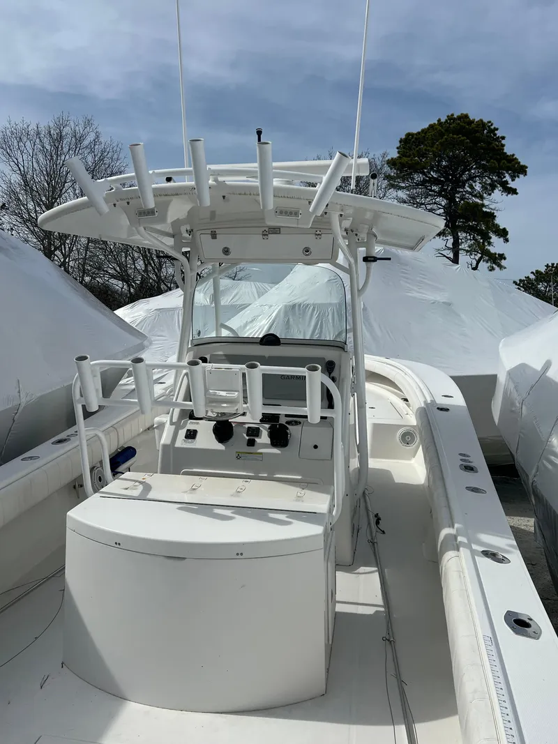 Slide: The Image of 2013 Regulator 34 Center Console boat with white deck and console, docked outdoors. - 30