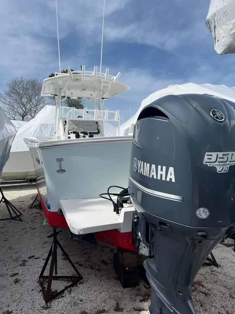 Slide: The Image of 2013 Regulator 34 Center Console boat with Yamaha engine, on stands, under clear sky. - 34