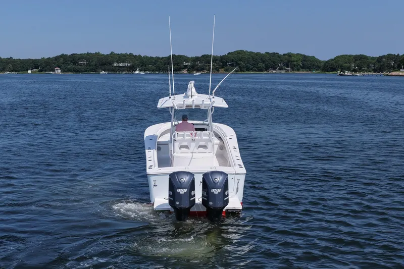 Slide: The Image of 2013 Regulator 34 Center Console boat on calm water, rear view with twin engines. - 4