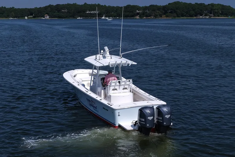 Slide: The Image of 2013 Regulator 34 Center Console boat cruising on a calm lake. - 5