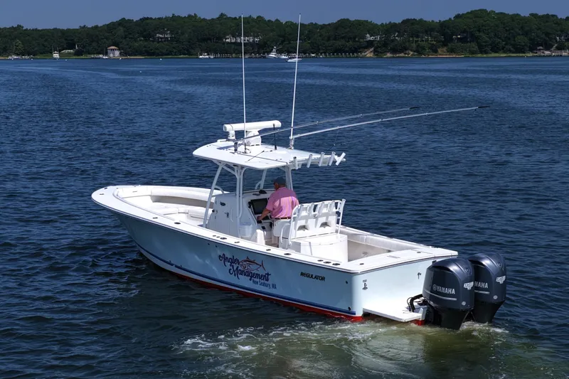 Slide: The Image of 2013 Regulator 34 Center Console boat on water with dual Yamaha engines. - 6