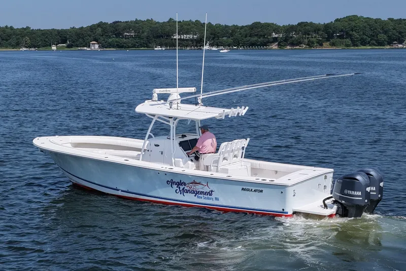 Slide: The Image of 2013 Regulator 34 Center Console boat on water, featuring dual Yamaha engines. - 7