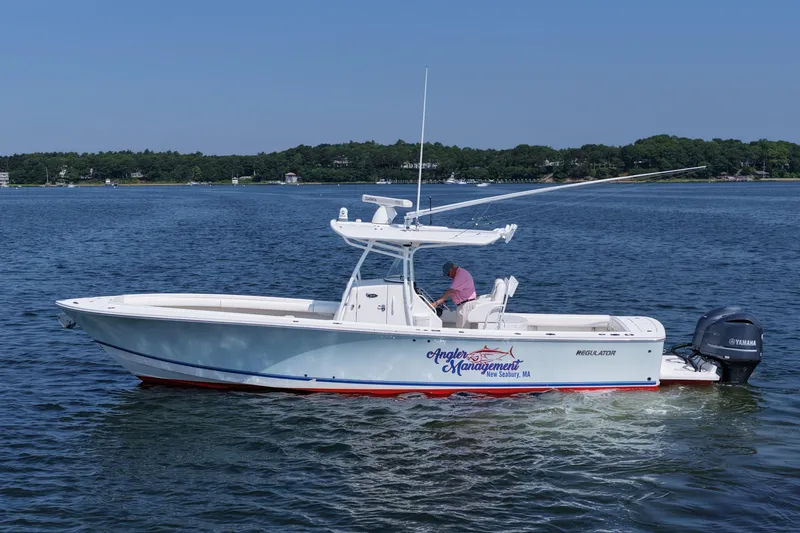Slide: The Image of 2013 Regulator 34 Center Console boat on water, side view, with Yamaha engines. - 8
