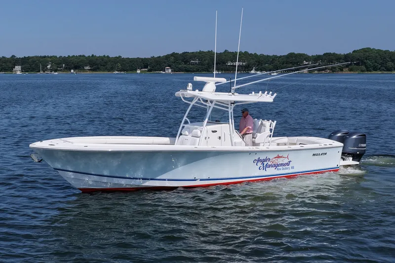 Slide: The Image of 2013 Regulator 34 Center Console boat cruising on a calm lake. - 9