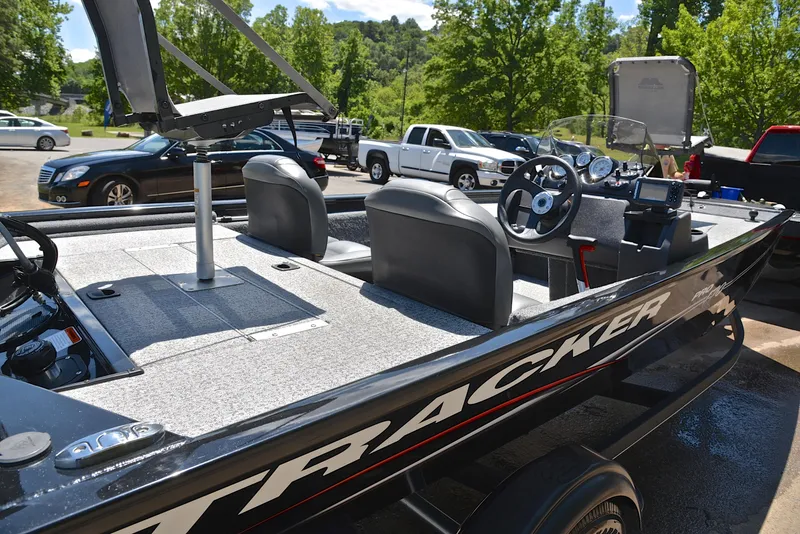 Slide: The Image of 2023 Bass Tracker Pro 170 boat with seating and steering wheel, parked outdoors. - 19