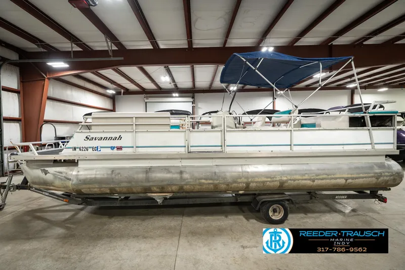 Slide: The Image of 1989 Crest 25 Savannah II pontoon boat in indoor storage with blue canopy. - 10