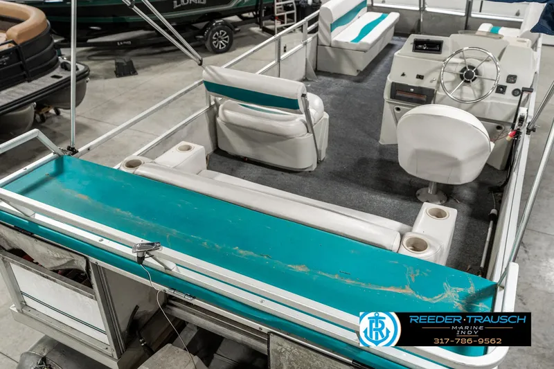 Slide: The Image of 1989 Crest 25 Savannah II pontoon boat interior with teal accents and seating. - 13