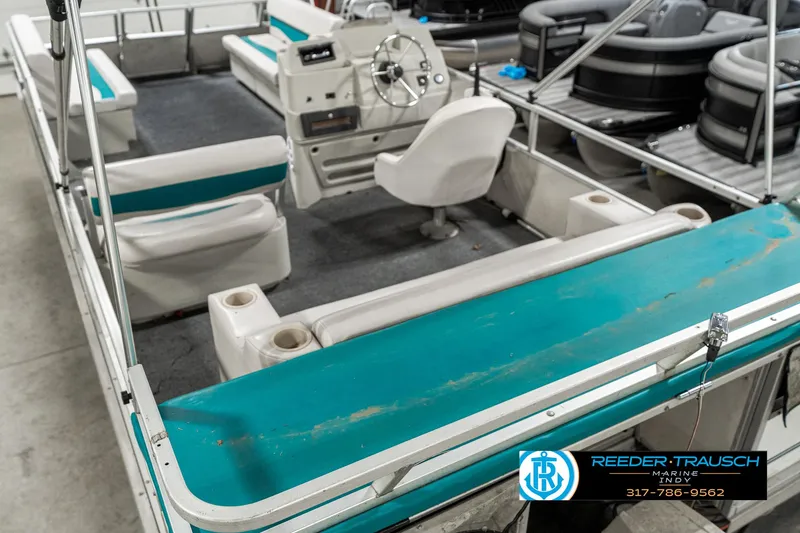 Slide: The Image of 1989 Crest 25 Savannah II pontoon boat interior with teal and white seating. - 14