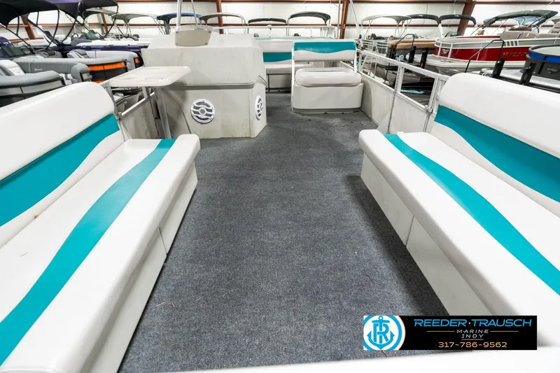 Slide: The Image of 1989 Crest 25 Savannah II pontoon boat interior with teal and white seating in showroom. - 15