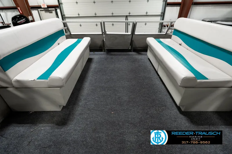 Slide: The Image of 1989 Crest 25 Savannah II boat interior with teal and white seating, carpeted floor. - 20
