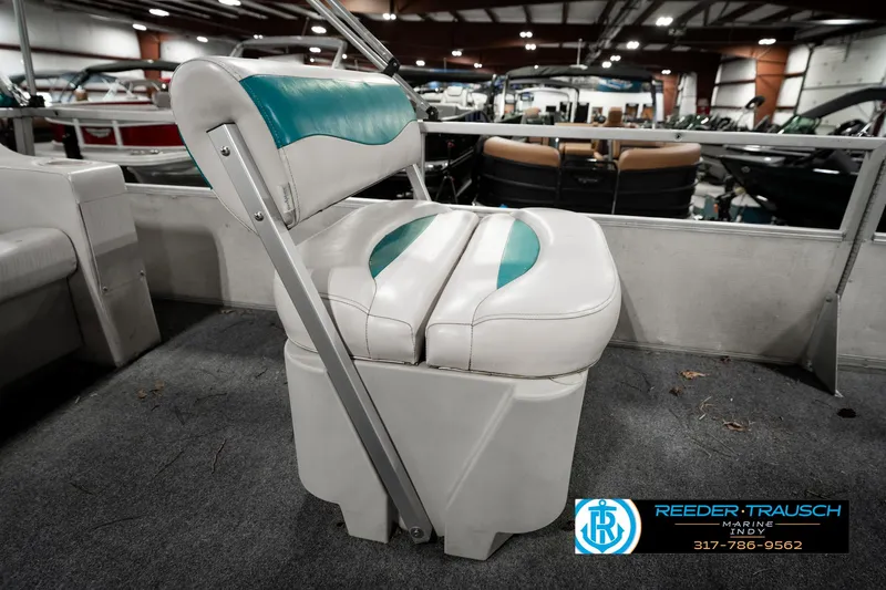 Slide: The Image of 1989 Crest 25 Savannah II boat seat with teal accents in showroom setting. - 22