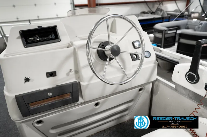 Slide: The Image of 1989 Crest 25 Savannah II boat steering console with wheel and controls in a showroom. - 29