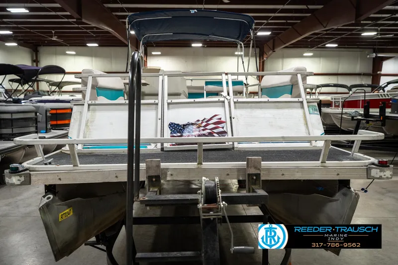 Slide: The Image of 1989 Crest 25 Savannah II pontoon boat in indoor showroom with American flag detail. - 4
