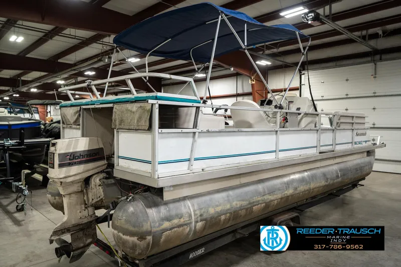Slide: The Image of 1989 Crest 25 Savannah II pontoon boat with Johnson outboard motor in indoor storage. - 7