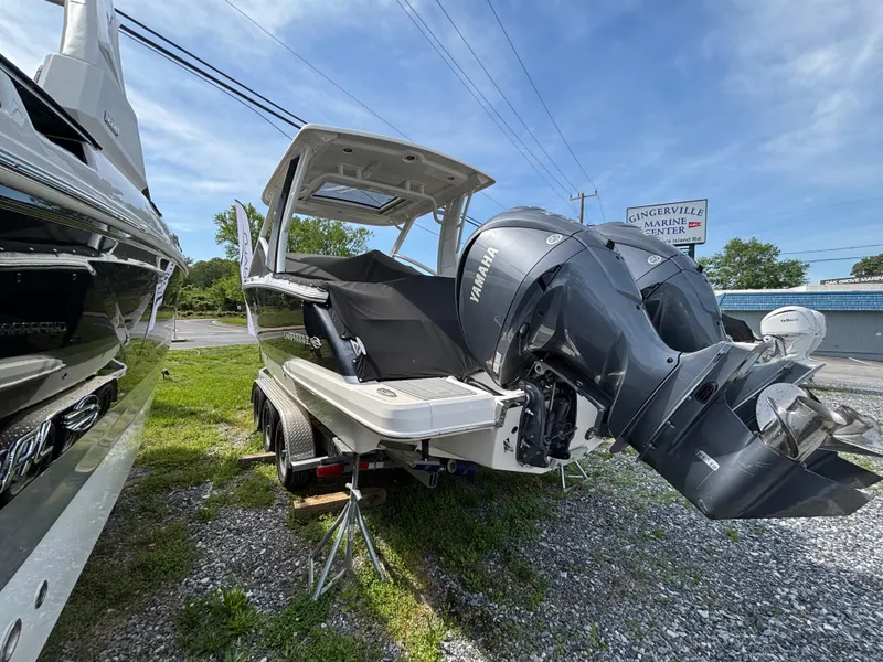 Slide: The Image of 2022 Chaparral 280 OSX boat with Yamaha outboard motor, displayed outdoors on a trailer. - 2