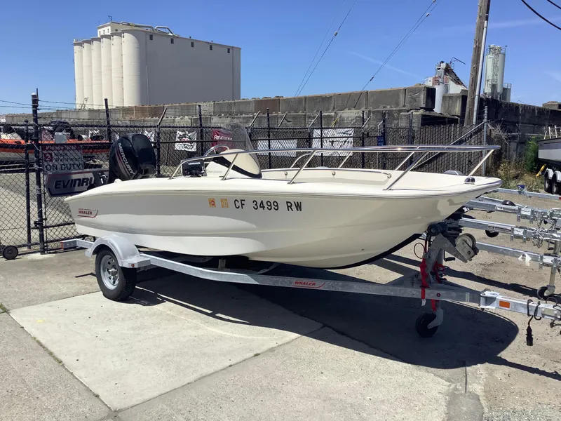 The Image of 2016 Boston Whaler 150 Super Sport boat on trailer, parked outdoors. - 1