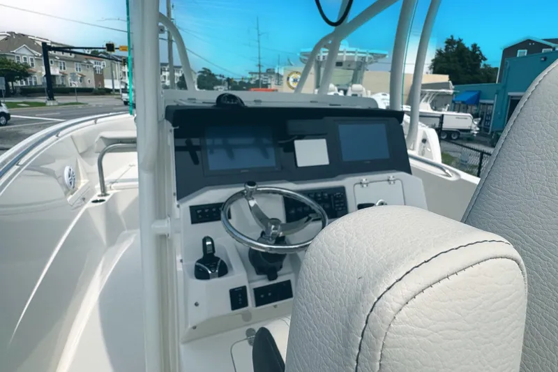 Slide: The Image of 2024 Sailfish 290 CC boat cockpit with modern controls and steering wheel. - 2