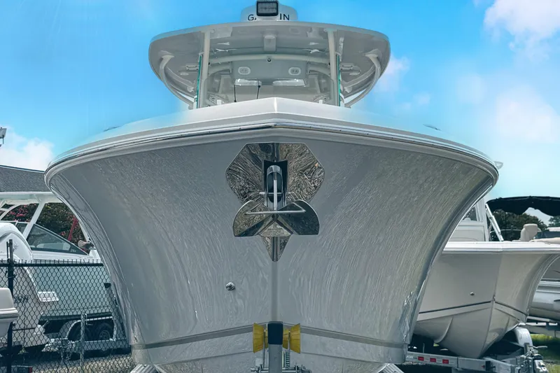 Slide: The Image of 2024 Sailfish 290 CC boat, front view, displayed outdoors under a clear blue sky. - 3
