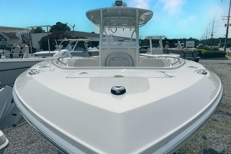 Slide: The Image of 2024 Sailfish 290 CC boat, sleek design, docked outdoors under clear blue sky. - 4