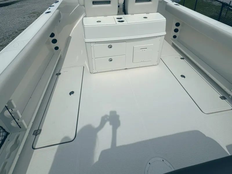 Slide: The Image of 2024 Sailfish 290 CC boat deck with storage compartments and seating area. - 7