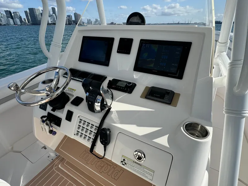 Slide: The Image of 2016 Intrepid 375 CC boat dashboard with steering wheel and navigation screens. - 10